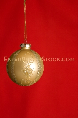 Christmas greeting card with gold ball on red vertical