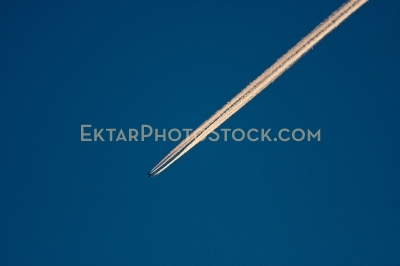Diagonal airplane trail in the deep blue sky