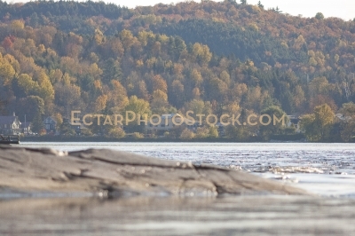 Rocky shore of Gatineau river and houses by the hill near Wakefield